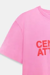 Remera de algodón color rosado con efecto lavado, de corte regular y cuello redondo, con texto rojo estampado en el frente que dice 'CENTER OF ATTENTION'.