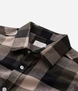 Camisa de franela para hombre, modelo comfort, con estampado de cuadros en tonos azules, blancos y negros, cuello camisero, manga larga y cierre frontal de botones.