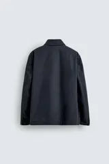 Parka de corte relajado confeccionada en mezcla de algodón. Presenta cuello solapa, cierre frontal con cremallera oculta y alamares metálicos, bolsillos de plastrón con solapa en la cadera y bolsillo de vivo en el pecho.