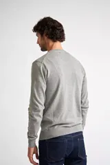 Sweater de tejido de punto con escote en V y manga larga. Presenta un diseño de calce regular con puños y ruedo acanalados, e incluye un pequeño logo bordado en el pecho.