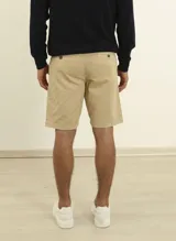 Bermuda de gabardina azul oscuro, corte recto, con bolsillos laterales y traseros.