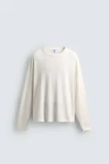 Camiseta de manga larga con cuello redondo y corte relajado, confeccionada en tejido de algodón liso color crudo.