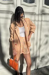 Short sastrero de lino con estampado de rayas verticales naranjas y blancas, corte holgado.