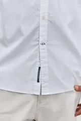 Camisa de manga larga en color celeste, con cuello clásico y cierre frontal de botones. Presenta un diseño de corte recto y acabado liso.