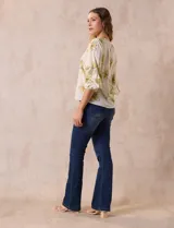 Blusa de gasa estampada con flores azules y violetas sobre fondo blanco, de manga 3/4 con volados.