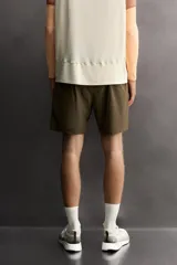 Shorts deportivos de entrenamiento Zara Athleticz, color beige, confeccionados en tejido técnico ligero y elástico con forro interior. Presentan cintura elástica ajustable, bolsillos frontales, bolsillo trasero de seguridad con cierre, aberturas laterales en el bajo y detalle de logo estampado en la pierna.