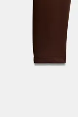 Body de manga larga con escote cuadrado, confeccionado en tejido elástico con cierre inferior mediante botones a presión.