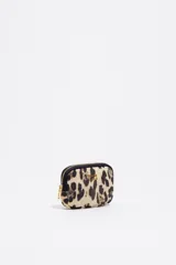 Monedero pequeño con estructura blanda, estampado animal print de leopardo en tonos beige y negro. Posee cierre de cremallera con tirador dorado y logo metálico de la marca en el frente.