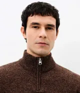 Suéter de punto con textura melange, cuello alto con cierre frontal parcial y mangas largas. Presenta un diseño estructurado y corte regular.