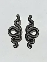 Aros colgantes con forma de serpiente blanca delineada con strass plateado.