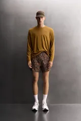 Shorts deportivos de Zara Athleticz confeccionados en tejido técnico ligero con estampado camuflado en tonos marrones y naranjas. Poseen cintura elástica ajustable, forro interior y aberturas en el bajo.