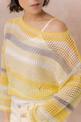 Buzo tejido de punto calado con rayas horizontales multicolor en tonos azul, amarillo, celeste y blanco, con escote bote, mangas largas y hombros caídos. Incluye top básico al tono.