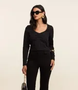 Blusa negra de algodón con escote en V y fruncido en el centro.