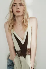 Vestido corto de tirantes finos ajustables con escote en pico. Presenta un diseño en color crema con detalles de encaje en color marrón a contraste en el escote, la cintura y el ruedo. Incluye forro interior.