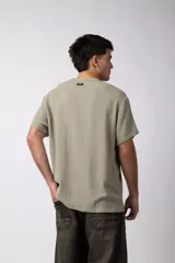 Remera de manga corta con cuello redondo, confeccionada en tejido de lino con textura entramada y corte holgado.