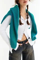 Top de manga larga color amarillo, confeccionado en tejido acanalado con cierre frontal de botones a presión metálicos. Presenta detalles de botones en los puños y un corte ajustado al cuerpo.