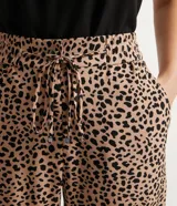 Pantalón fluido con estampado de leopardo, cintura elástica con lazo ajustable, bolsillos laterales y cierre con botón.