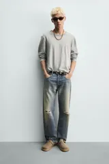 Zueco tipo mule de hombre, color beige topo, fabricado en piel con acabado serraje. Presenta una tira con hebilla metálica cuadrada en el empeine y suela gruesa de goma en color natural contrastante.