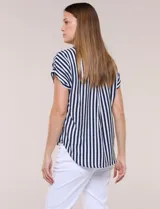 Camisa de calce holgado color blanco con rayas verticales negras, cuello camisero clásico, abotonadura frontal y mangas cortas.