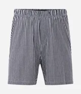 Pijama masculino de algodón, compuesto por una remera blanca con estampado de Garfield y la frase "Mondays Suck", y un short con rayas verticales blancas y negras. Incluye pantuflas negras de felpa.