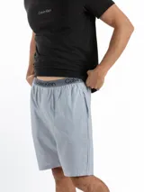 Conjunto de pijama Calvin Klein compuesto por una remera negra de algodón con logo estampado en el pecho y un short celeste con cintura elástica con logo.