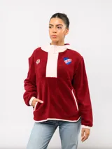 Buzo de micropolar color bordó con capucha, cierre frontal parcial y detalles en color crema. Presenta el logo de Umbro y el escudo del Club Nacional de Football bordados en el frente.