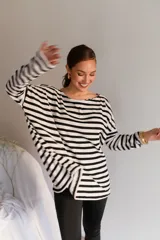 Buzo de viscosa de corte holgado, con diseño a rayas horizontales en blanco y negro, escote bote y mangas largas caídas.