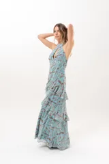 Vestido largo celeste con estampado abstracto en tonos marrones, escote halter con abertura en el frente y volados escalonados en la falda.