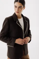 Blazer color verde oscuro con solapas con pespuntes blancos, de corte recto y cierre con un botón.