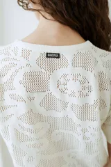 Remera de tejido de punto color celeste, de manga corta, con diseño calado en el frente.