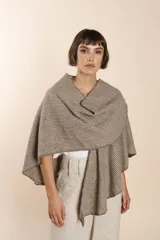 Ruana corta de lana fina color beige con rayas horizontales y terminación de crochet hecho a mano. Prenda cómoda, versátil y fácil de combinar.