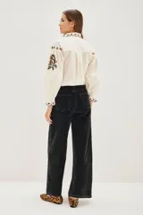 Pantalón de pana marrón, de corte wide leg, con tiro medio y bolsillos delanteros y traseros.