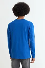 Remera de manga larga con cuello redondo, confeccionada en tejido de algodón y poliéster, con puños elásticos en las mangas.