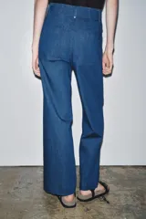 Jeans de tiro alto y pierna ancha de Zara, confeccionados en mezcla de algodón color beige. Presentan cintura con trabillas, bolsillos de parche en la espalda, costuras frontales marcadas y cierre delantero con cremallera, botón y gancho metálico.