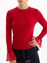 Top de tejido de punto fino color negro, con ajuste al cuerpo, cuello redondo y mangas largas que terminan en puños acampanados con detalle de tejido calado.