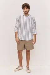 Camisa de manga larga de lino con diseño de rayas verticales en tonos azul y blanco, cuello clásico y cierre frontal de botones.