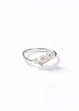 Anillo de plata 925 con diseño abierto que presenta tres perlas de río naturales de distintos tamaños y pequeños detalles de zirconias incrustadas en la base.