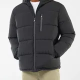 Campera acolchada tipo puffer color negro, con capucha ajustable, cierre frontal completo y bolsillos laterales con cierre.