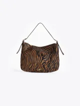 Cartera de hombro confeccionada en cuero con pelo vacuno, con estampado animal print tipo cebra en tonos marrón y negro. Presenta cierre superior, herrajes dorados y correa regulable con hebillas laterales.