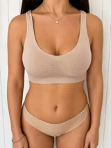 Top deportivo de microfibra color beige, con diseño sin aros, escote redondo y detalle de tejido acanalado en el centro y en la banda inferior.