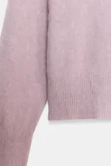 Jersey de punto con textura efecto cepillado, cuello en V y manga larga con terminaciones en rib.