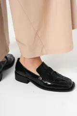 Mocasín de cuero charol negro con diseño enrejillado en la capellada y horma cuadrada.