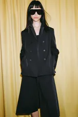 Blazer cruzado Zara de color negro, con cuello de solapa, manga larga y bolsillos laterales ocultos en la costura. Cuenta con cierre frontal de botones.