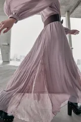 Vestido midi de color rosado con escote en pico y mangas largas. Presenta un diseño combinado con paneles de encaje en el frente y cierre frontal con botones forrados. Incluye un cinturón de cuero sintético marrón con hebilla metálica dorada.