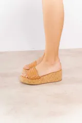 Sandalia con plataforma de corcho y capellada tejida de cuero vacuno.