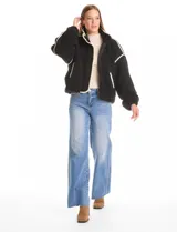 Campera negra de símil corderito, marca Elan. Tiene cuello alto, cierre frontal con solapa y botones, bolsillos inclinados en la parte delantera y ruedo y puños elastizados. Forro interno a tono.