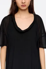 Vestido midi de corte línea A, confeccionado en tejido fluido con paneles de distinta textura. Presenta cuello redondo, mangas cortas y un diseño asimétrico en el ruedo que aporta movimiento.