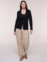 Blazer de silueta semientallada color negro, confeccionado en sastrería liviana con solapa muesca clásica, cierre frontal de un solo botón y bolsillos frontales.