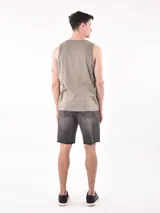 Musculosa sin mangas color verde militar con cuello redondo. Estampado frontal en blanco y negro que simula una fotografía de palmeras en la playa con texto en la parte inferior.