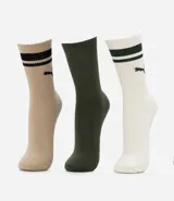 Kit de tres pares de medias deportivas Puma de caña larga. Un par es beige con dos rayas marrones y logo de Puma. Otro par es blanco liso. El tercer par es marrón oscuro con dos rayas blancas y logo de Puma. Todas están confeccionadas en algodón.